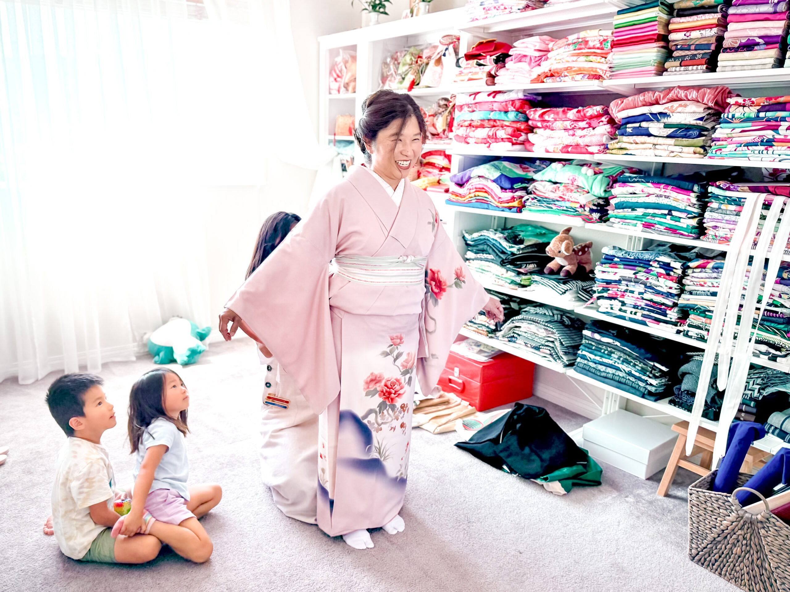 Mother wearing kimono while children watch during Shichi-Go-San celebration in Los Angeles